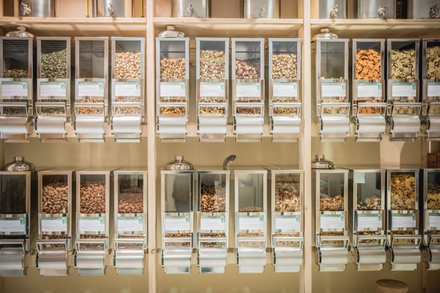 Un mur de distributeurs Zero Waste Dispenser remplis de fruits secs, dans une épicerie vrac